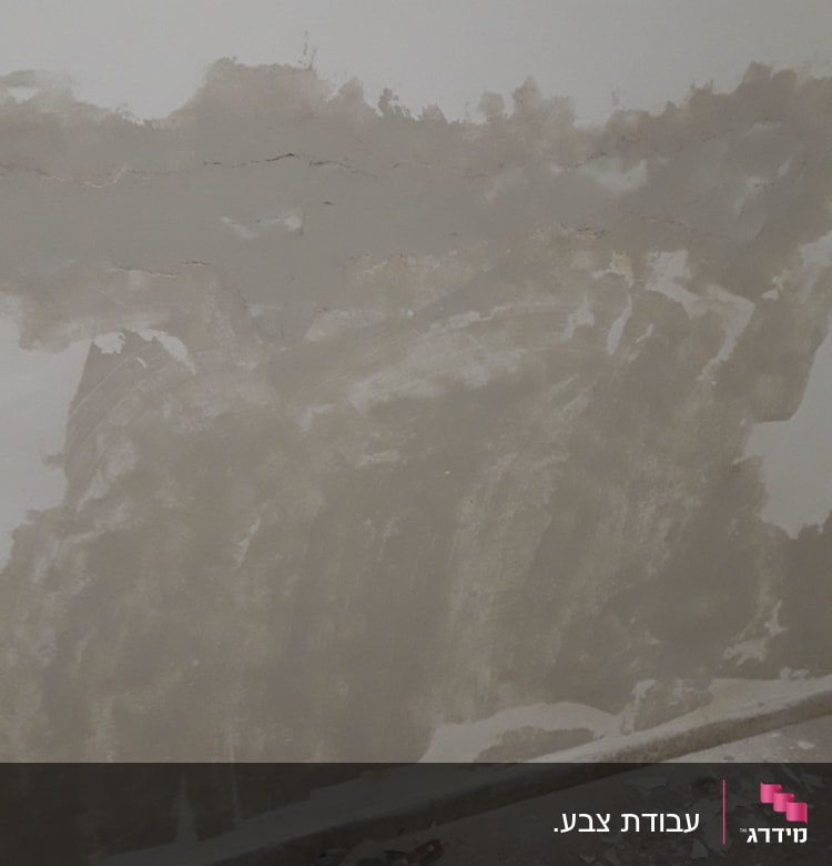 קיר עם טיח מתקלף וכלי עבודה לצביעה